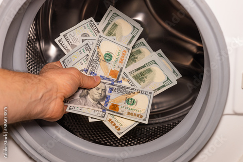 American dollars being put into the washing machine, Concept, Money laundering, Illegal business proceeds, Dark business, Black market, Bundle of 100 dollar bills