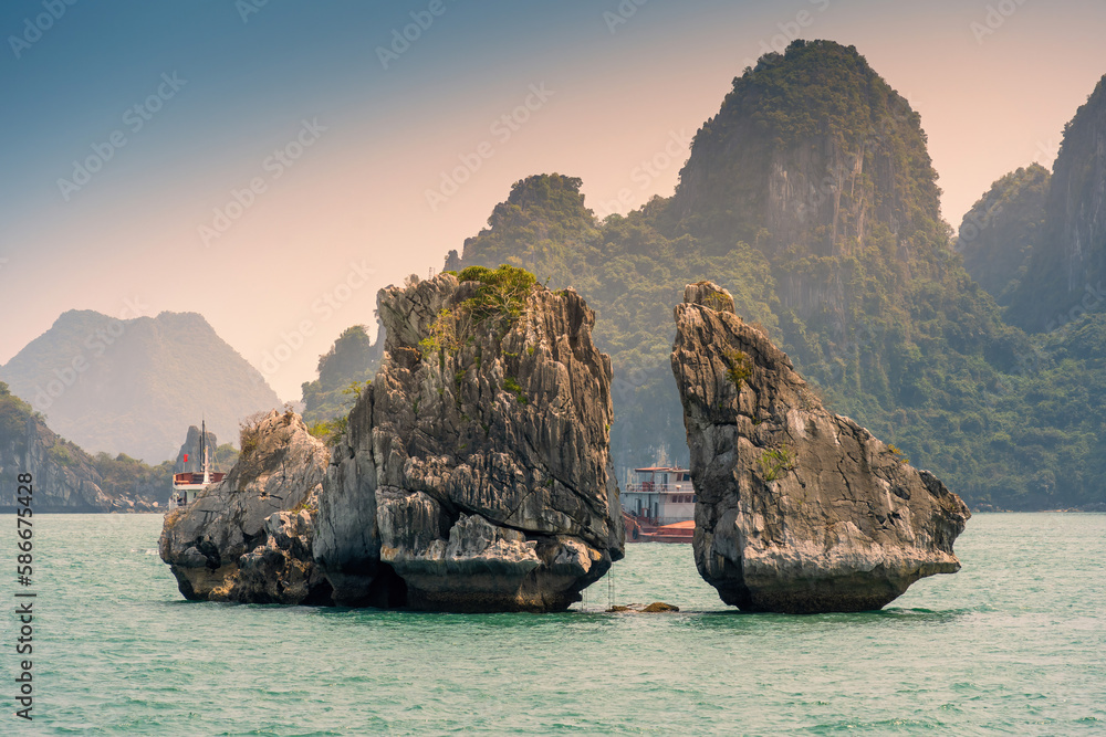 View of Hon Ga Choi Island or Cock and Hen, Fighting Cocks Island located in Ha Long bay, Vietnam, Trong Mai island, junk boat cruise and boats, popular landmark