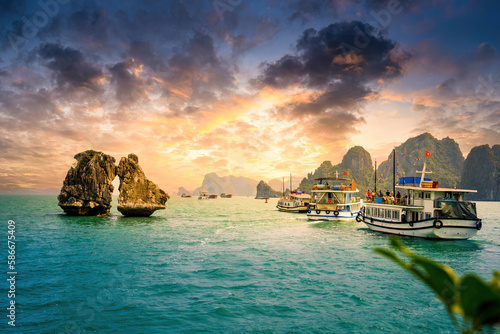 View of Hon Ga Choi Island or Cock and Hen, Fighting Cocks Island located in Ha Long bay, Vietnam, Trong Mai island, junk boat cruise and boats, popular landmark photo