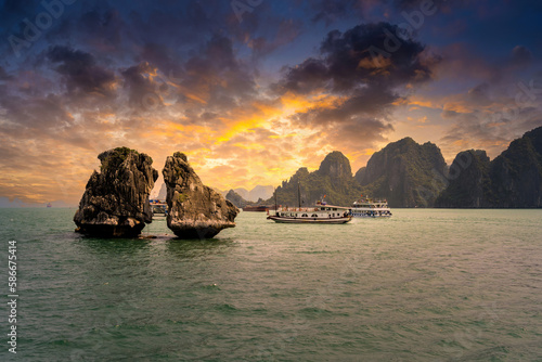 View of Hon Ga Choi Island or Cock and Hen  Fighting Cocks Island located in Ha Long bay  Vietnam  Trong Mai island  junk boat cruise and boats  popular landmark