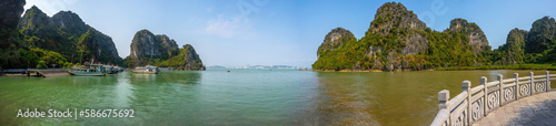 View of Ha Long Bay  with a lot of limestone islets and cruise ships  on a blue sky summer day.