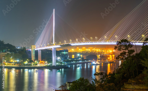 Fototapeta Naklejka Na Ścianę i Meble -  Colorful night view of Bai Chay Bridge, connecting two parts of Ha Long City, Hon Gai City and Bai Chay City through Cua Luc Bay.