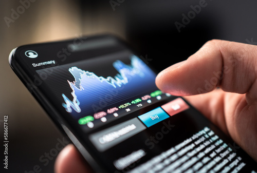 Stock market trade with phone. Finance analysis graph and chart in crypto currency, forex, index fund or etf mobile app. Stockmarket broker and investor holding smartphone in hand. Risk investing.