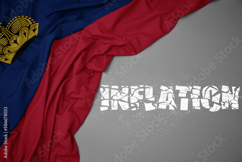 waving colorful national flag of liechtenstein on a gray background with broken text inflation. 3d illustration photo