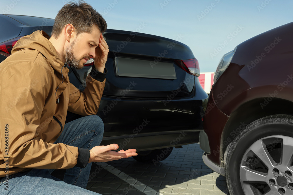 Stressed man near car with scratch outdoors. Auto accident Stressed man near car with scratch outdoors. Auto accident