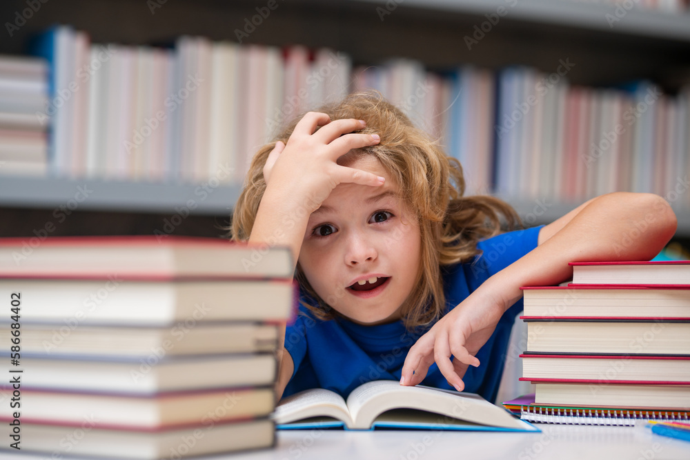 Nerd pupil. School child pupil reading book at school. Kid doing homework, sitting at table by books, in classroom. Nerd pupil. School child pupil reading book at school. Kid doing homework, sitting at table by books, in classroom.
