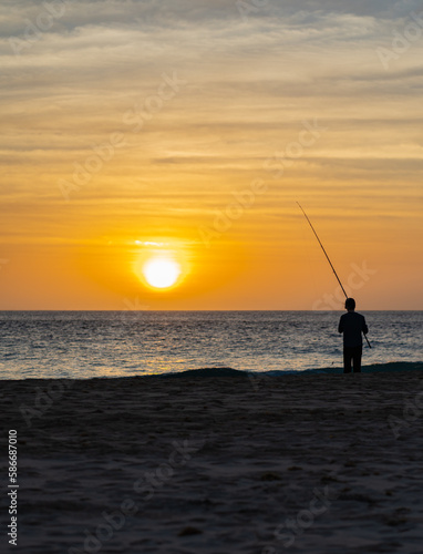 Silhouette Man fishing at sunset.