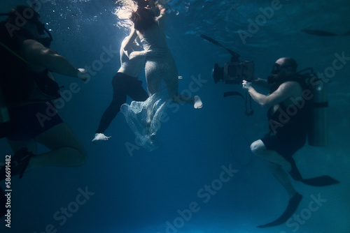 filming a movie underwater underwater cameraman and actors © Pavel Karchevskii