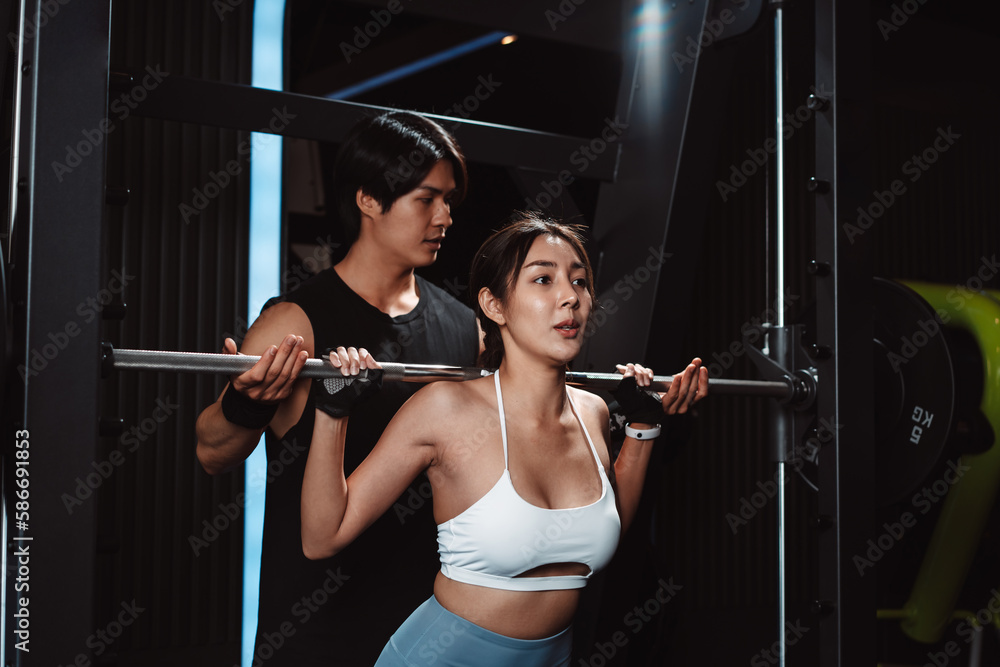 Woman working out Bodybuilder with coaching assistance to support weights at the gym. bodybuilder doing exercises with barbell. training sport healthy lifestyle bodybuilding... Woman working out Bodybuilder with coaching assistance to support weights at the gym. bodybuilder doing exercises with barbell. training sport healthy lifestyle bodybuilding...