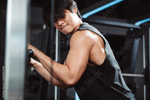 Man working out with weights training machine exercise lifting dumbbells at fitness gym. Fitness muscular body weight loss. Bodybuilding healthy lifestyle.