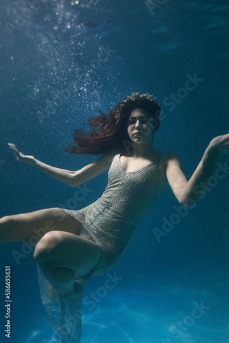 beautiful young girl under water in a long white dress with long hair the magic of the sea