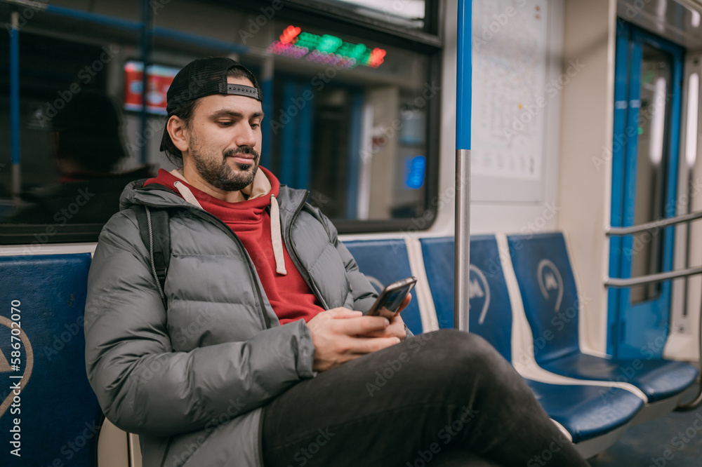 Fototapeta premium A young man rides standing in a modern subway car.
