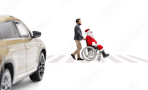 Full length profile shot of a man pushing santa claus in a wheelchair at a pedestrian crossing