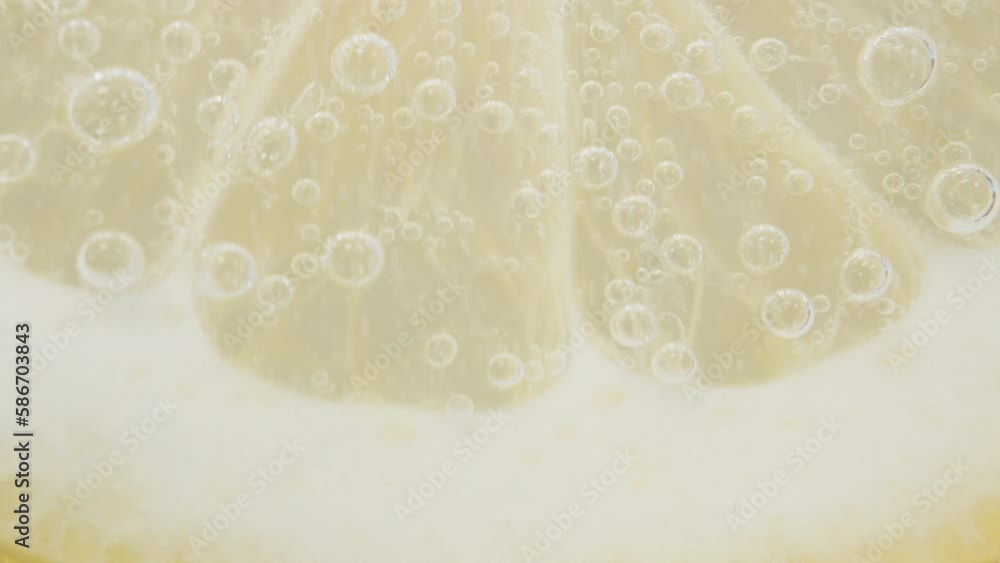 A slice of Lemon in a glass of Soda. Bubbles rise up, macro. A slice of Lemon in a glass of Soda. Bubbles rise up, macro.