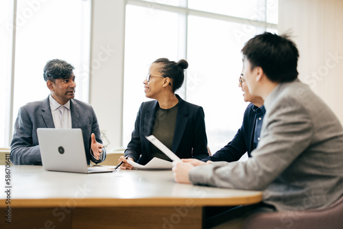 Cheerful woman in her 40 s in business meeting with colleagues, teamwork, discussion, connection