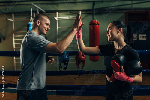 Trainer supports a boxing girl after a good workout