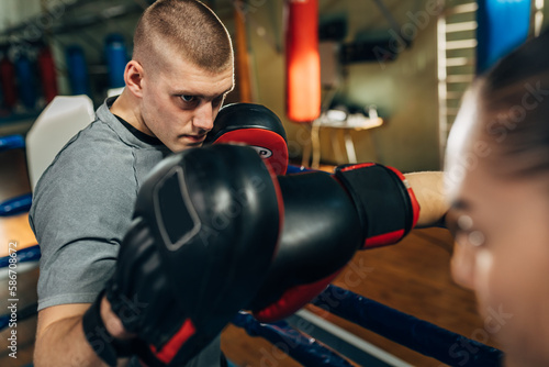 Closeup view of a boxing coach with pads during training