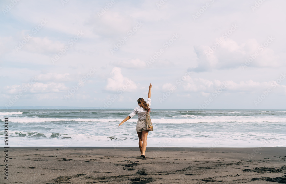 Happy woman with arms raised on sandy beach Happy woman with arms raised on sandy beach