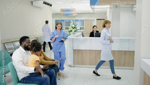 Diversity in hospital lobby or hallway with busy nurse, older patient on wheelchair, sick patient, relative waiting at reception 
