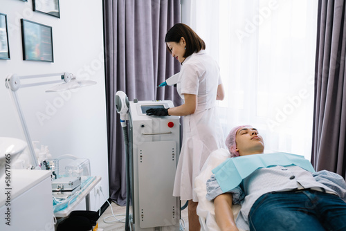 Professional cosmetologist preparing neodymium laser for photo epilation