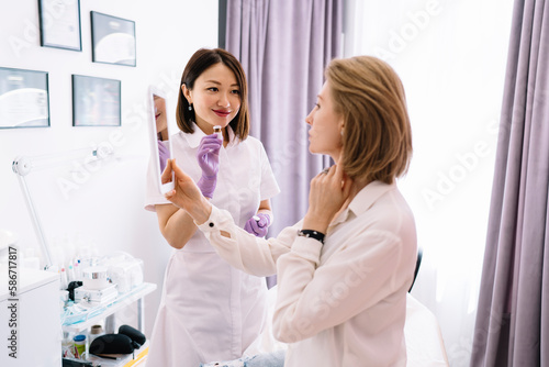 Concentrated female client looking at mirror after procedure