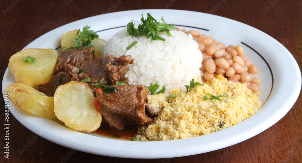 Roast Beef with potatoes served with rice, beans and farofa