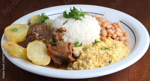 Roast Beef with potatoes served with rice, beans and farofa