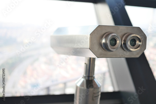 Coin-operated binoculars looking out over city ,