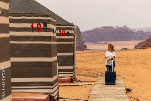 Wadi Rum Jordan A blonde woman checks into a desert cam accommodation.  photo