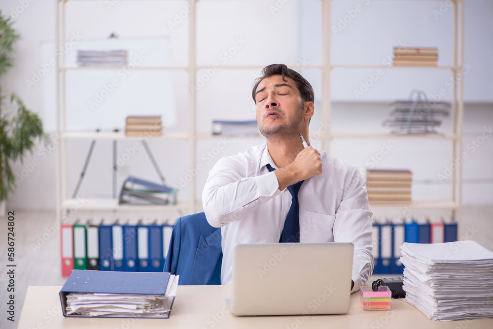 Young male employee and too much work in the office