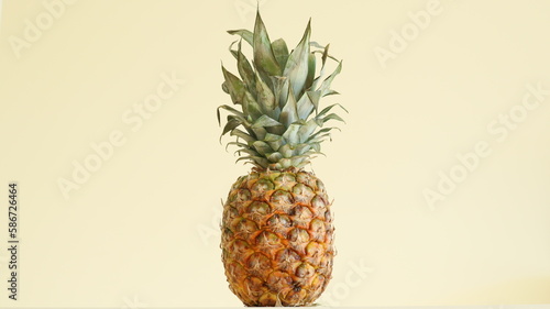 A poster photo of a pineapple. A single pineapple in photo. A fresh photo of a pineapple. A monochromatic photo of a fruit. A yellow background. A bright picture.