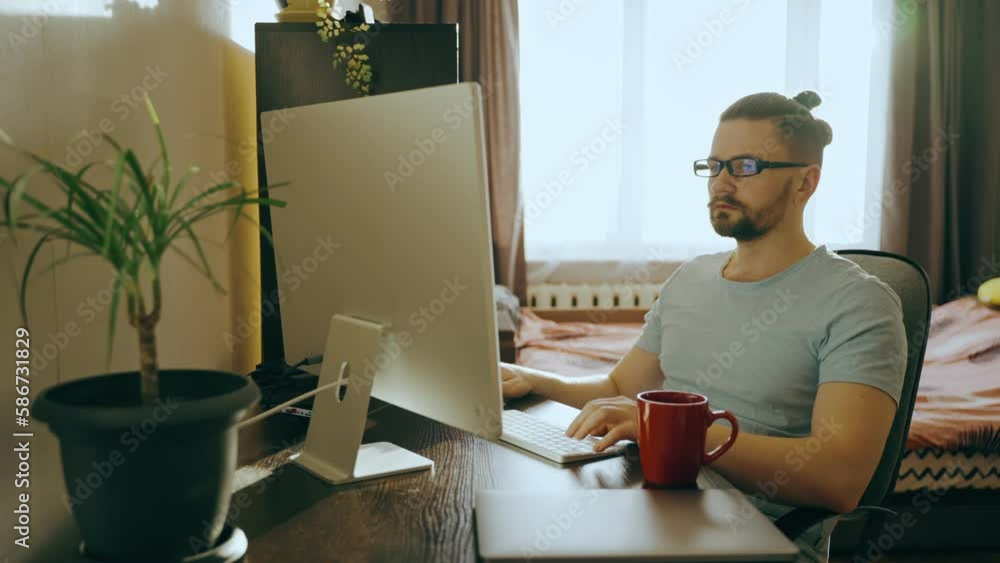 Portrait of a business man working on a computer at home and drinking tea,coffee Portrait of a business man working on a computer at home and drinking tea,coffee