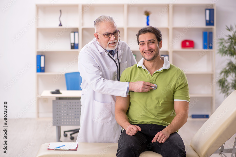 Fototapeta premium Young male patient visiting old male doctor