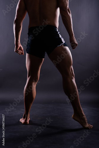 Muscular male legs close up studio shot dark background