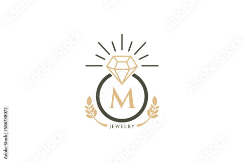 Vintage vector logo ring with sparkling diamond and letter M in the center of circle and leaves decoration. Jewelry, fashion, wedding and metal crafts icon.