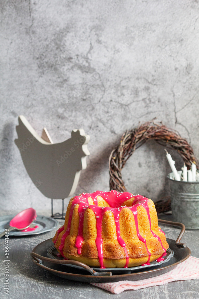 Orange vanilla cake covered with pink icing, Easter decor.