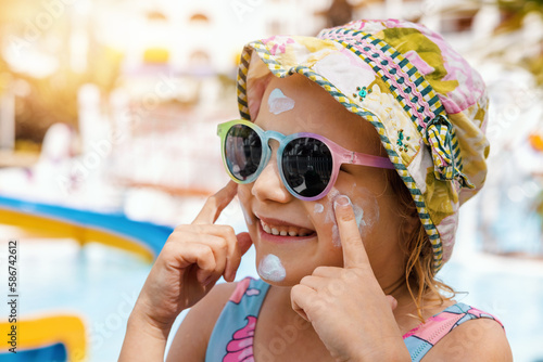 Fotografie child put on sunscreen on face. skin protection from sunburn