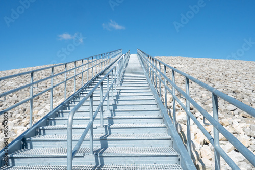 Challenging obstacle of outdoor stainless steel steps climbing nearly straight up into the sky, great cardio workout for athletic training at facility