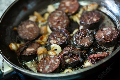Closeup of pan with traditional Spanish morcilla blood sausage slices with rice frying with onions photo