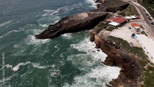 Aerial drone view of drone fast-approaching Boca do Inferno in Cascais, Portugal while tilting down photo