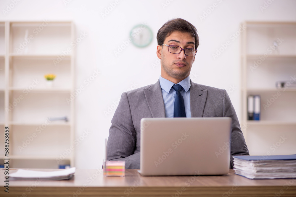 Young male employee working in the office Young male employee working in the office