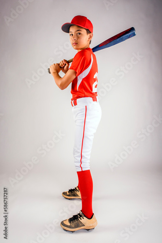 Canvas Print Young teenage baseball player model in baseball uniform standing in studio with