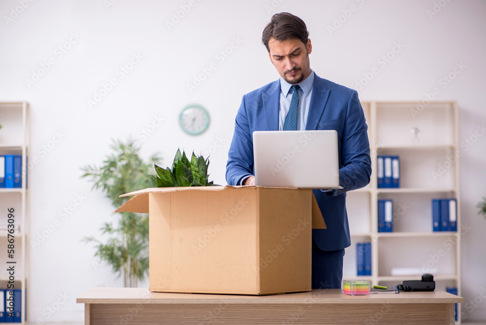 Young male employee in business relocation concept Young male employee in business relocation concept