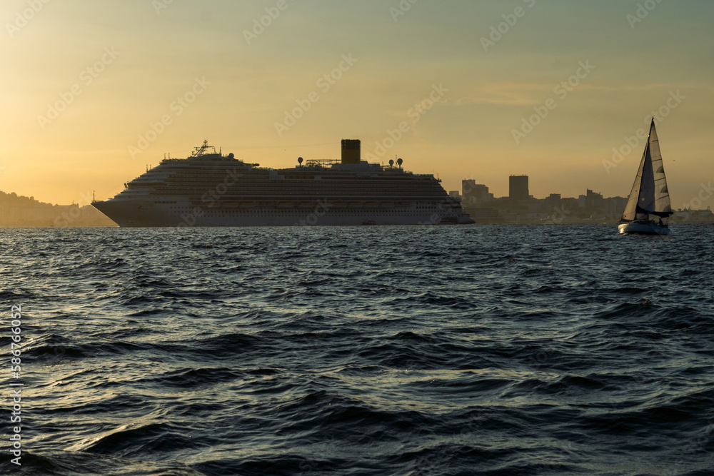 Transatlantic ship in Guanabara Bay in Rio de Janeiro, Brazil with a hill in the background. Beautiful landscape with the sea at sunset. Sailing boats and speedboats in the bay Transatlantic ship in Guanabara Bay in Rio de Janeiro, Brazil with a hill in the background. Beautiful landscape with the sea at sunset. Sailing boats and speedboats in the bay