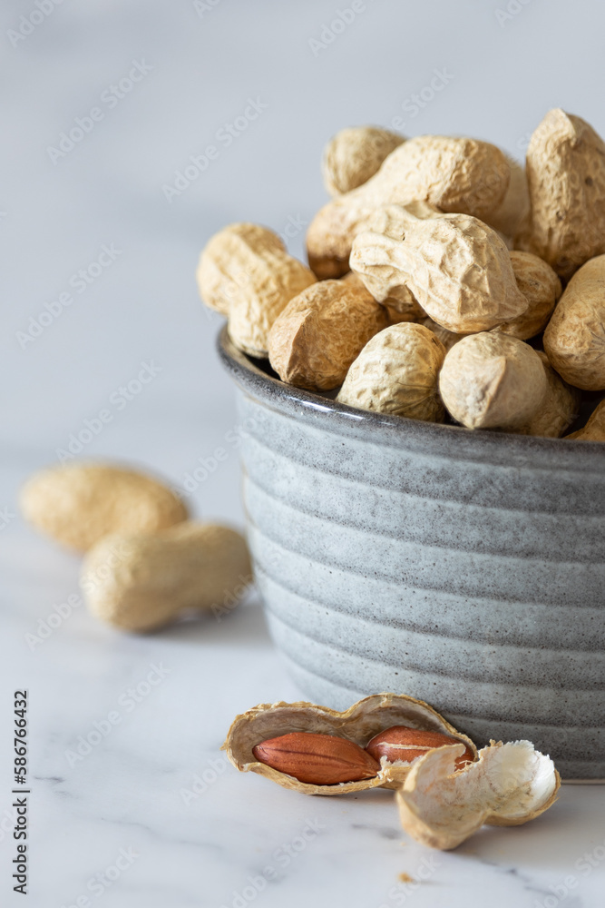 Fototapeta Peanuts in a pill in a bowl and peeled peanuts. Composition