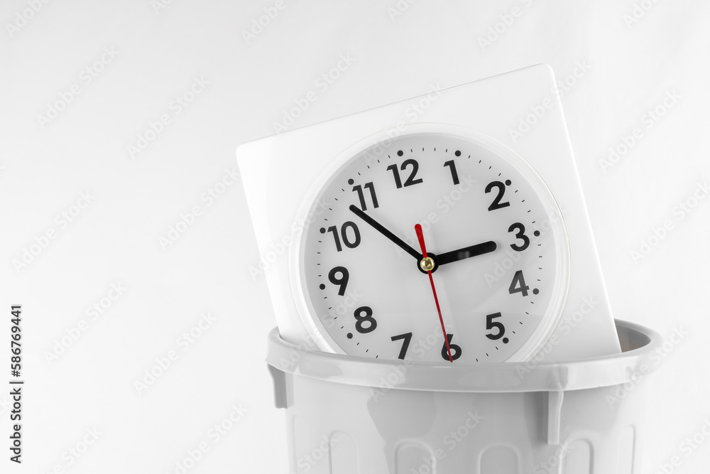 時計とゴミ箱。時間を無駄遣いするイメージ