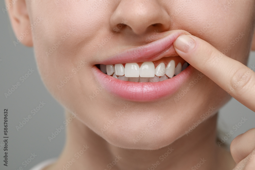 Fototapeta premium Woman showing healthy gums on grey background, closeup