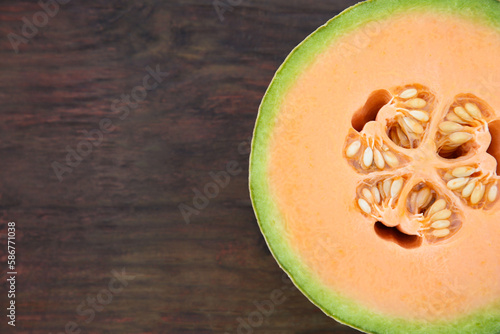 Half of fresh ripe melon on wooden table, top view. Space for text