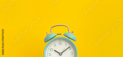 Alarm clock on yellow background. Top view. Flat lay. Back to school concept.