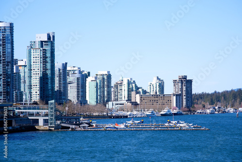 Canada Place and commercial buildings in downtown Vancouver port and pier where ships arrive people strolling skyscrapers tall buildings Pacific Ocean © Oleksandra